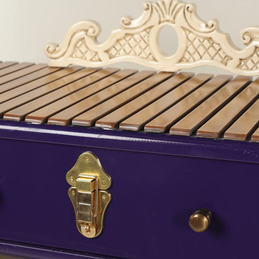 Detalle del Aparador Boutine con frente morado, herraje dorado y listones superiores.