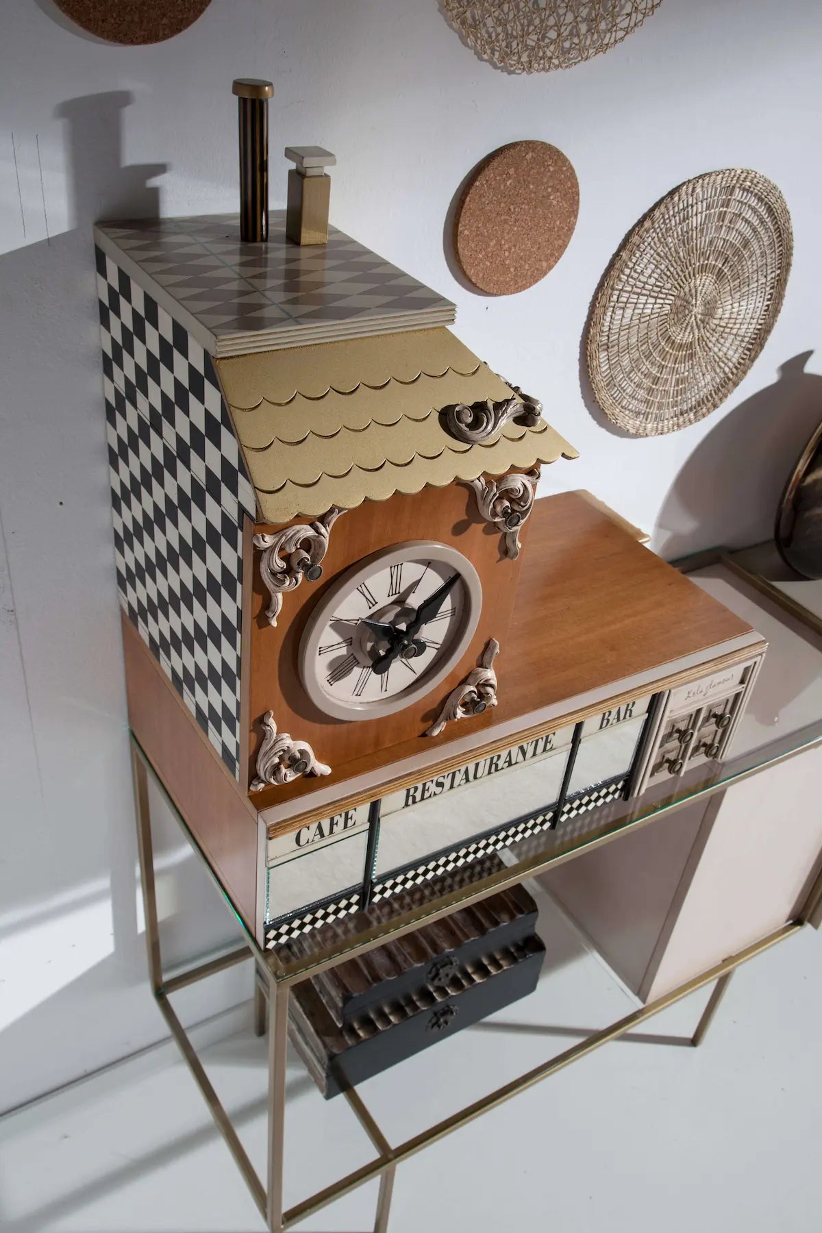 Detalle del Aparador Manhattan con reloj decorativo, vitrina, motivos en damero y estructura metálica