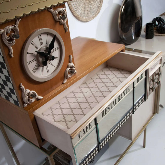 Detalle del Aparador Manhattan con reloj decorativo, cajón abierto, cristal y motivos gráficos