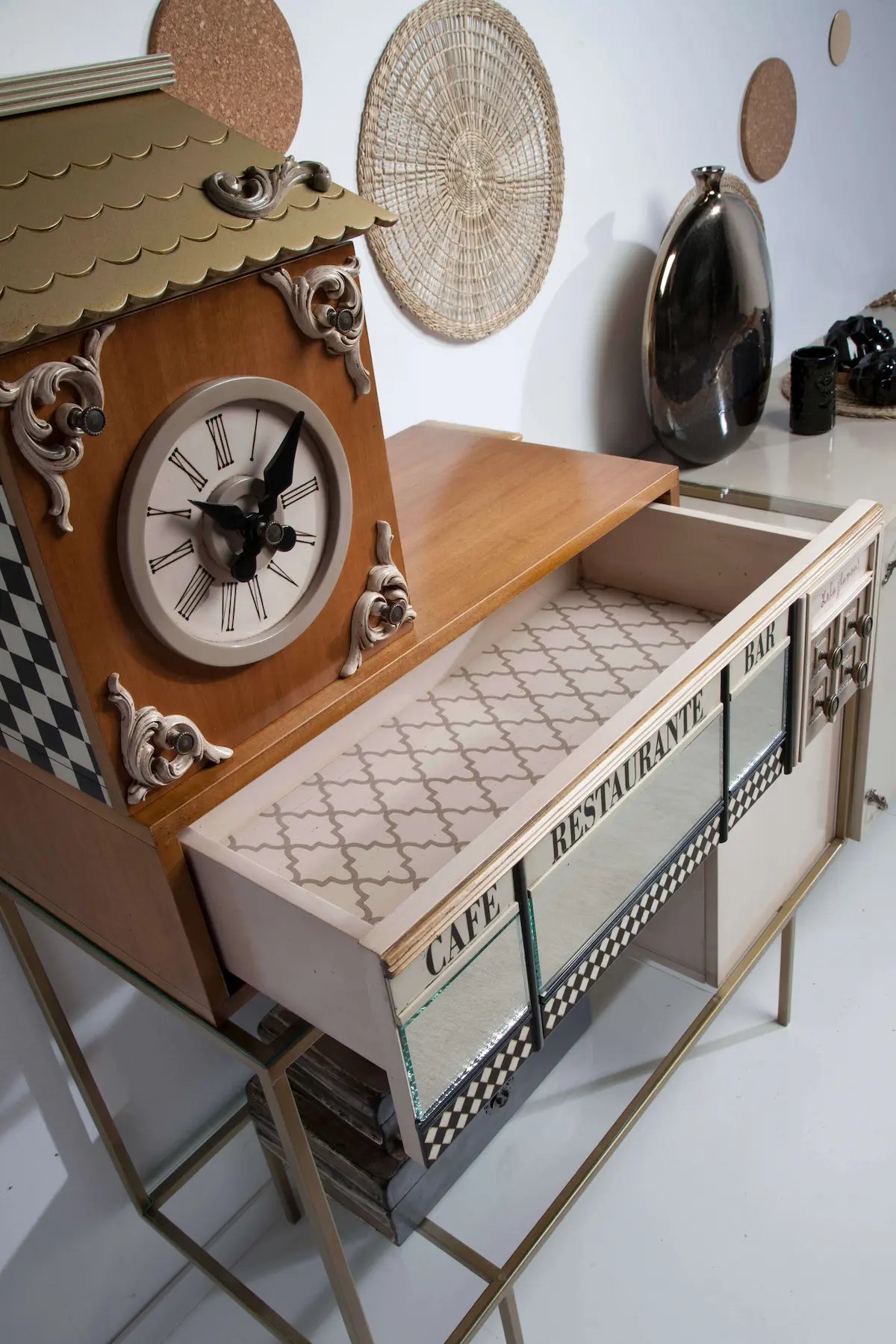 Detalle del Aparador Manhattan con reloj decorativo, cajón abierto, cristal y motivos gráficos