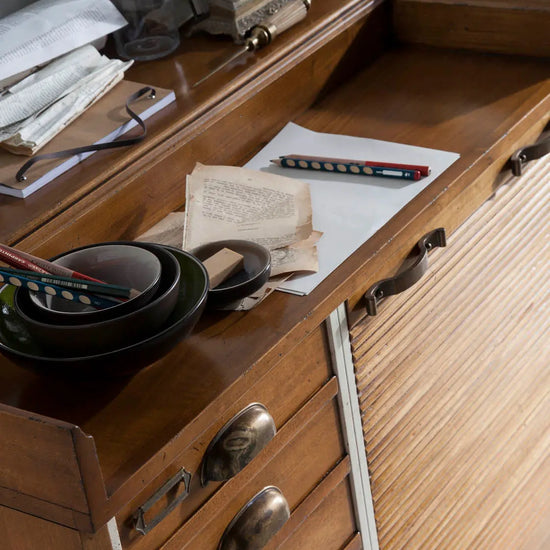 Detalle de la encimera del Aparador Seller con acabado en madera cálida y objetos decorativos