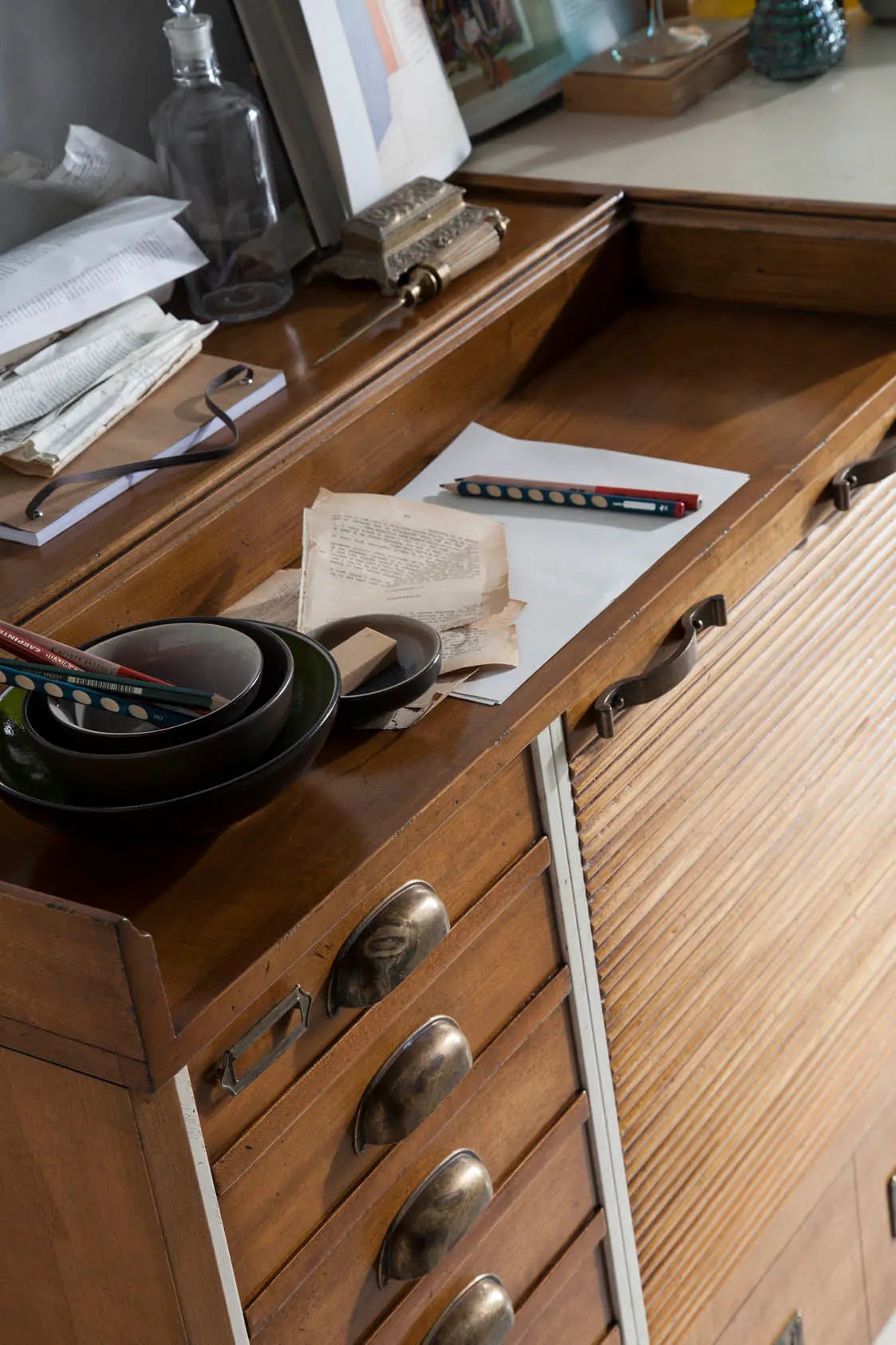 Detalle de la encimera del Aparador Seller con acabado en madera cálida y objetos decorativos