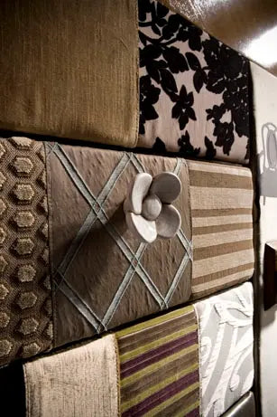 Detalle del tirador dorado en forma de corazón del Armario Dinastía sobre frente negro y paneles textiles combinados.