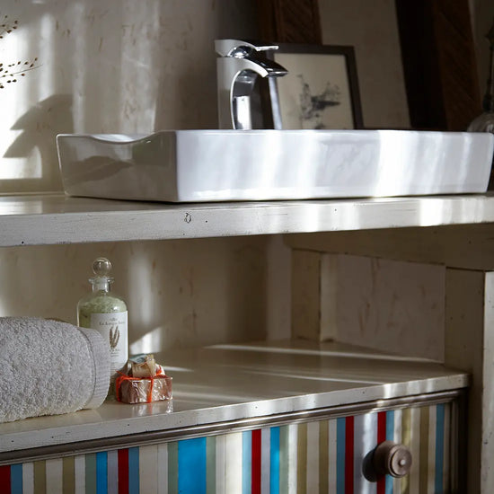 Mueble lavabo artesanal tipo banco carpintero en madera maciza con almacenaje abierto y cajón.