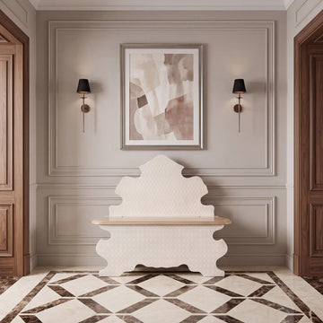 Banco Vincent en un recibidor elegante, con respaldo escultórico y silueta de curvas ornamentales.