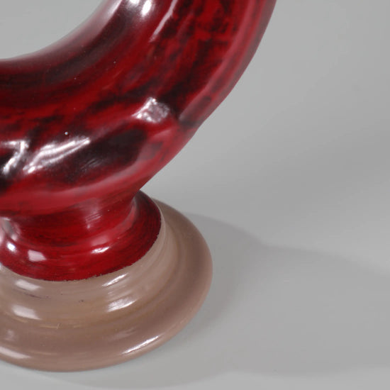 Detalle inferior del Botijo Blood con cuerpo rojo oscuro y base en tono beige suave.