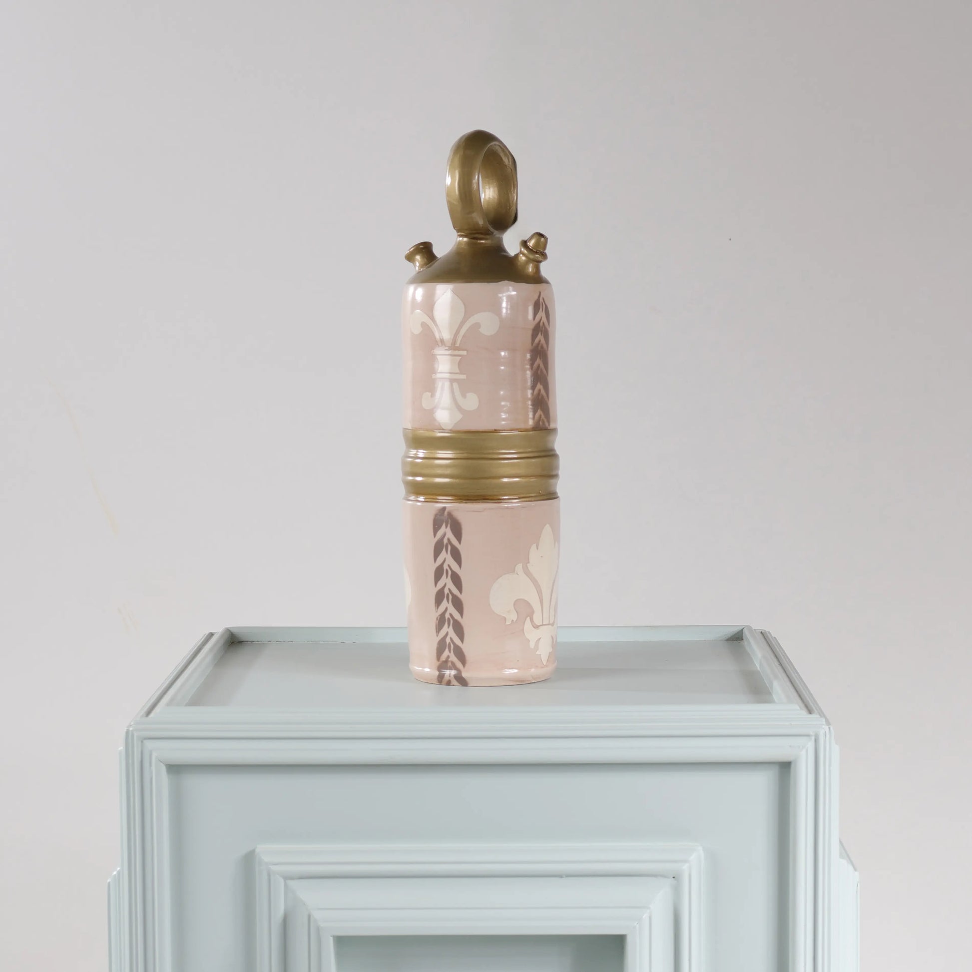 Botijo Brat decorativo en rosa empolvado y dorado con motivos de flor de lis.
