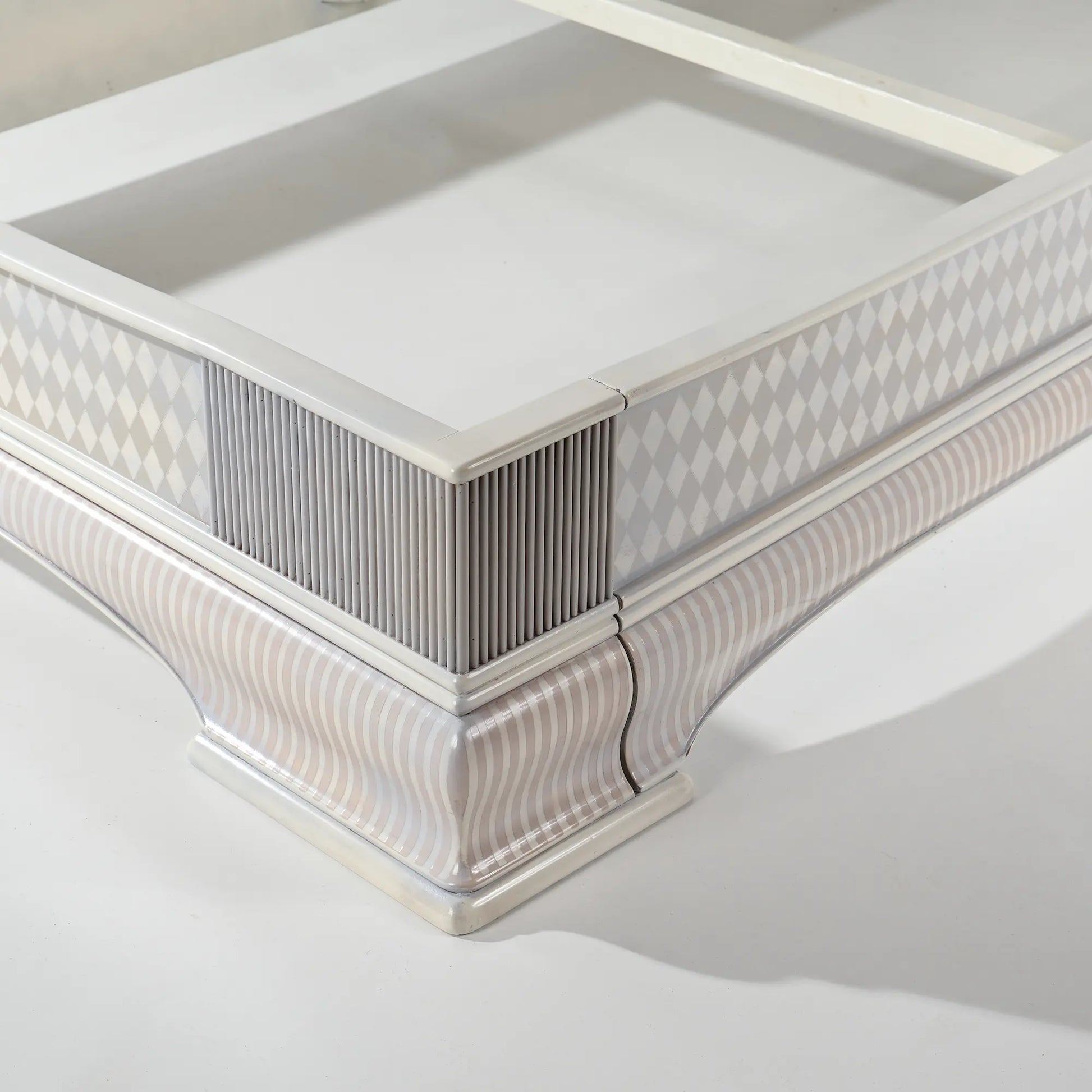 Detalle del piecero de la cama Giulietta con molduras y patrón geométrico artesanal