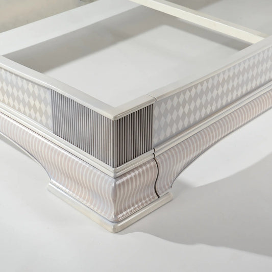 Detalle del piecero de la cama Giulietta con molduras y patrón geométrico artesanal
