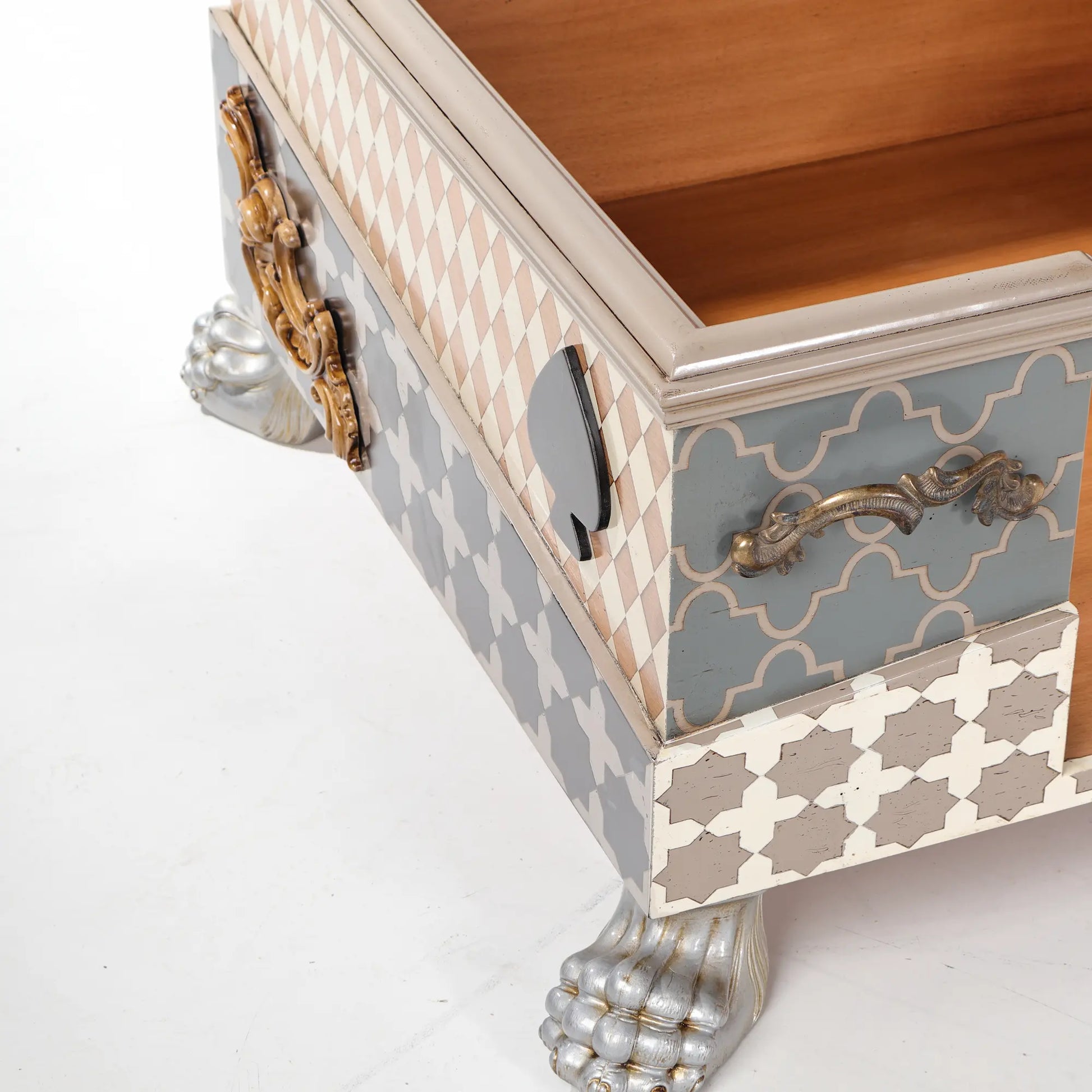 Detalle de la Casita Divina con motivo de naipe, aplique ornamental y pata de apariencia plateada.