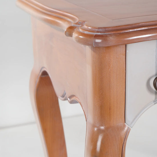 Primer plano de la moldura superior y la pata curva de la consola Araya.