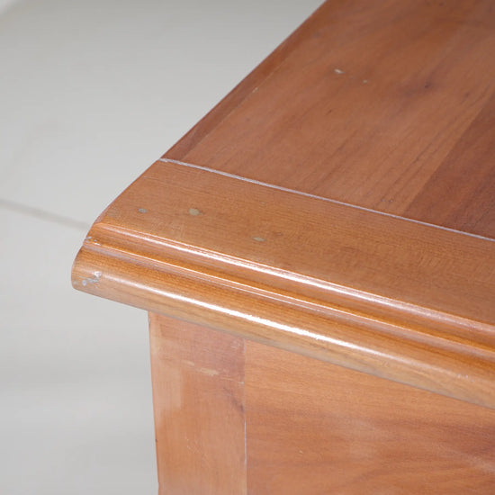 Detalle del tablero superior de la consola Araya, con veta visible y borde moldurado.