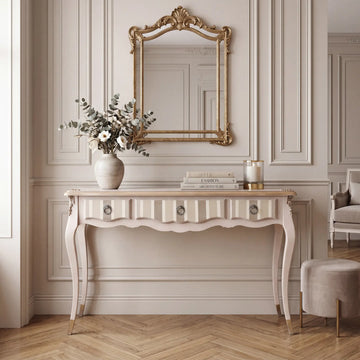 Consola Teresa de 3 cajones en ambiente clásico con espejo dorado, molduras de pared y decoración elegante.