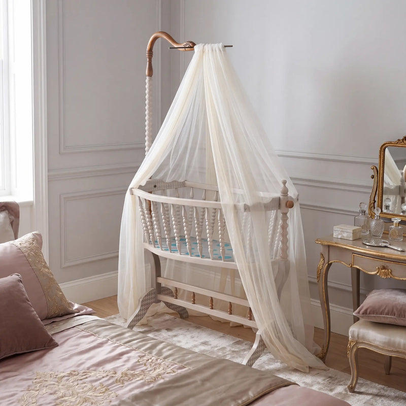 Cuna Bambino en dormitorio infantil elegante con dosel de tela ligera.