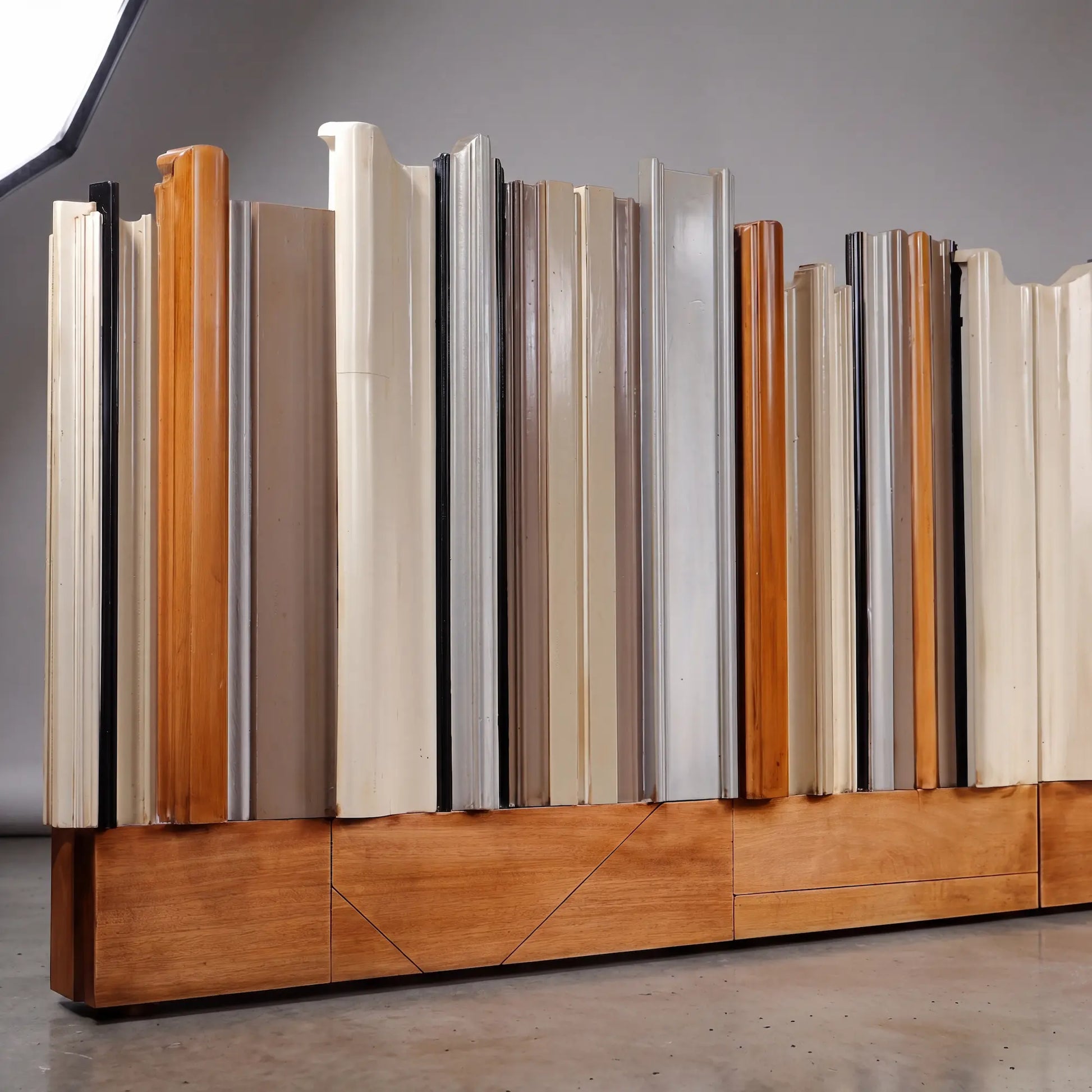 detalle de cabecero de madera Reina con formas onduladas y combinación de acabados en tonos neutros