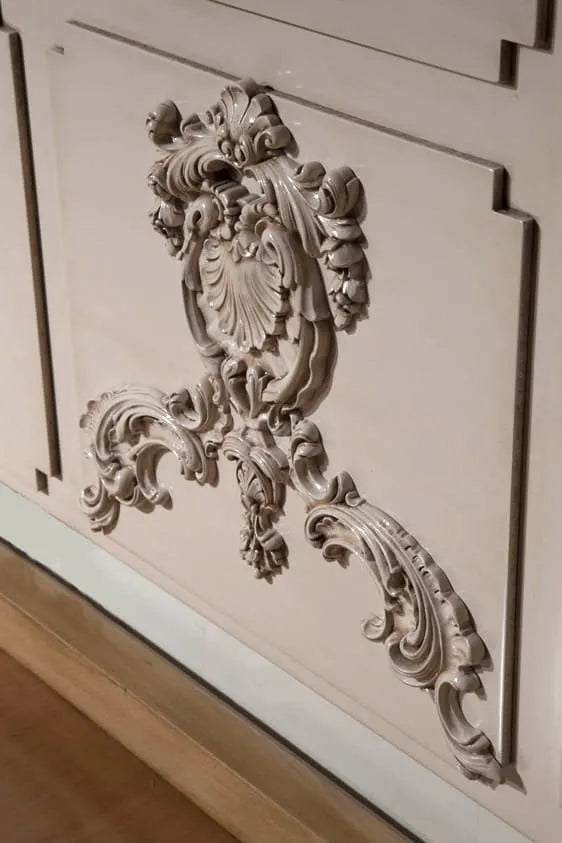 Detalle tallado ornamental del cabecero Utopía realizado en madera lacada.