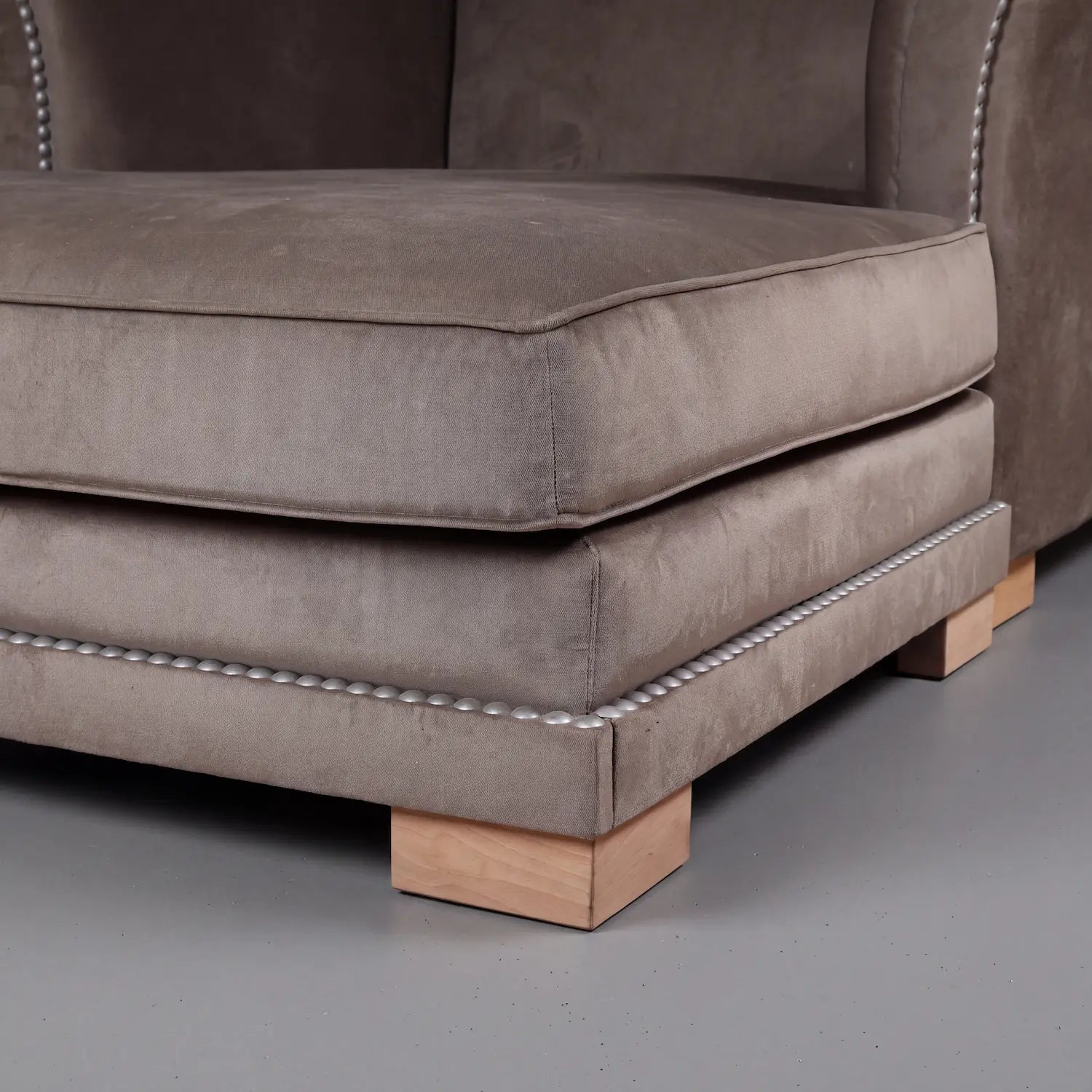 detalle de chaise longue Cats con asiento amplio tapizado en tela y base con tachuelas decorativas