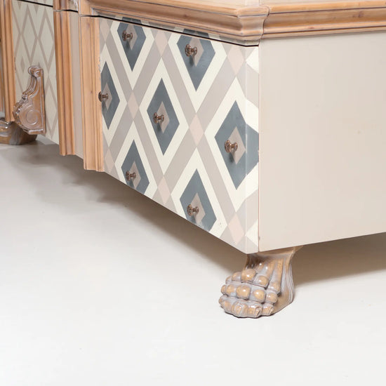 detalle de cómoda Seda con frontal decorado geométrico y pata tallada de estilo clásico