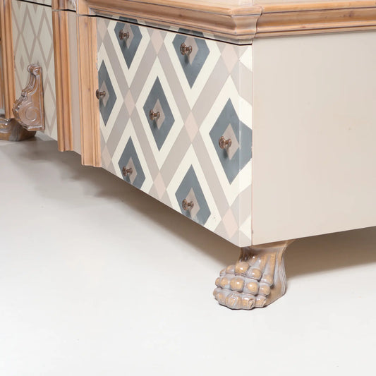 detalle de cómoda Seda con frontal decorado geométrico y pata tallada de estilo clásico
