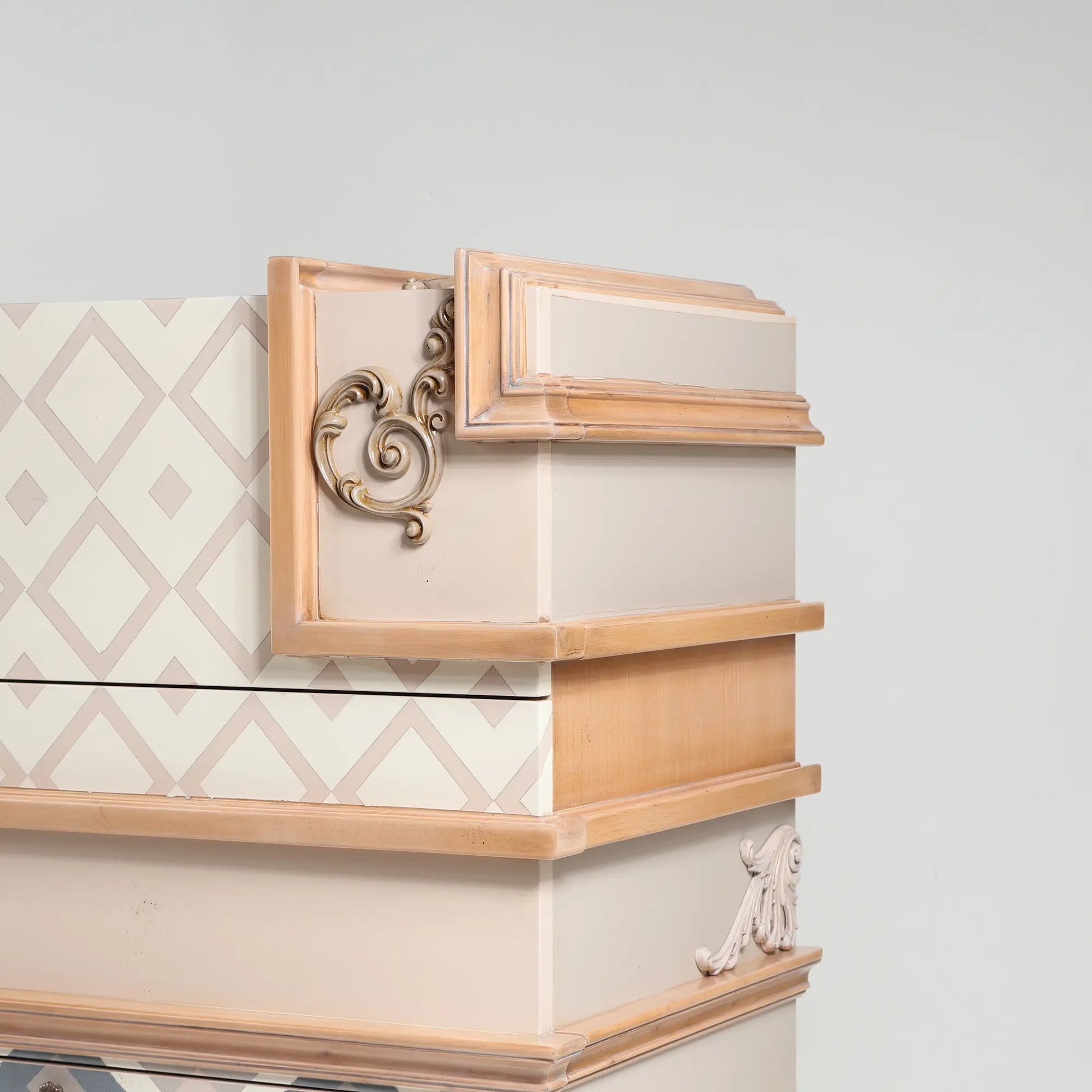 detalle lateral de cómoda Seda con ornamento tallado y acabado en tonos crema y madera