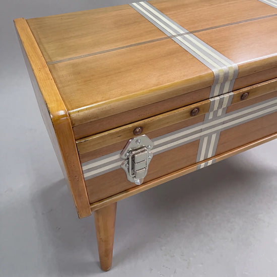 Detalle de la mesa de centro Suitcase con herrajes metálicos y líneas decorativas.