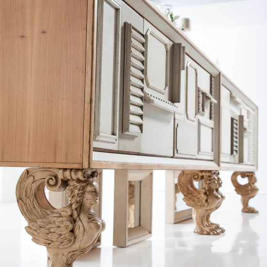 Aparador de diseño Lamassu en madera clara con patas escultóricas en un interior elegante