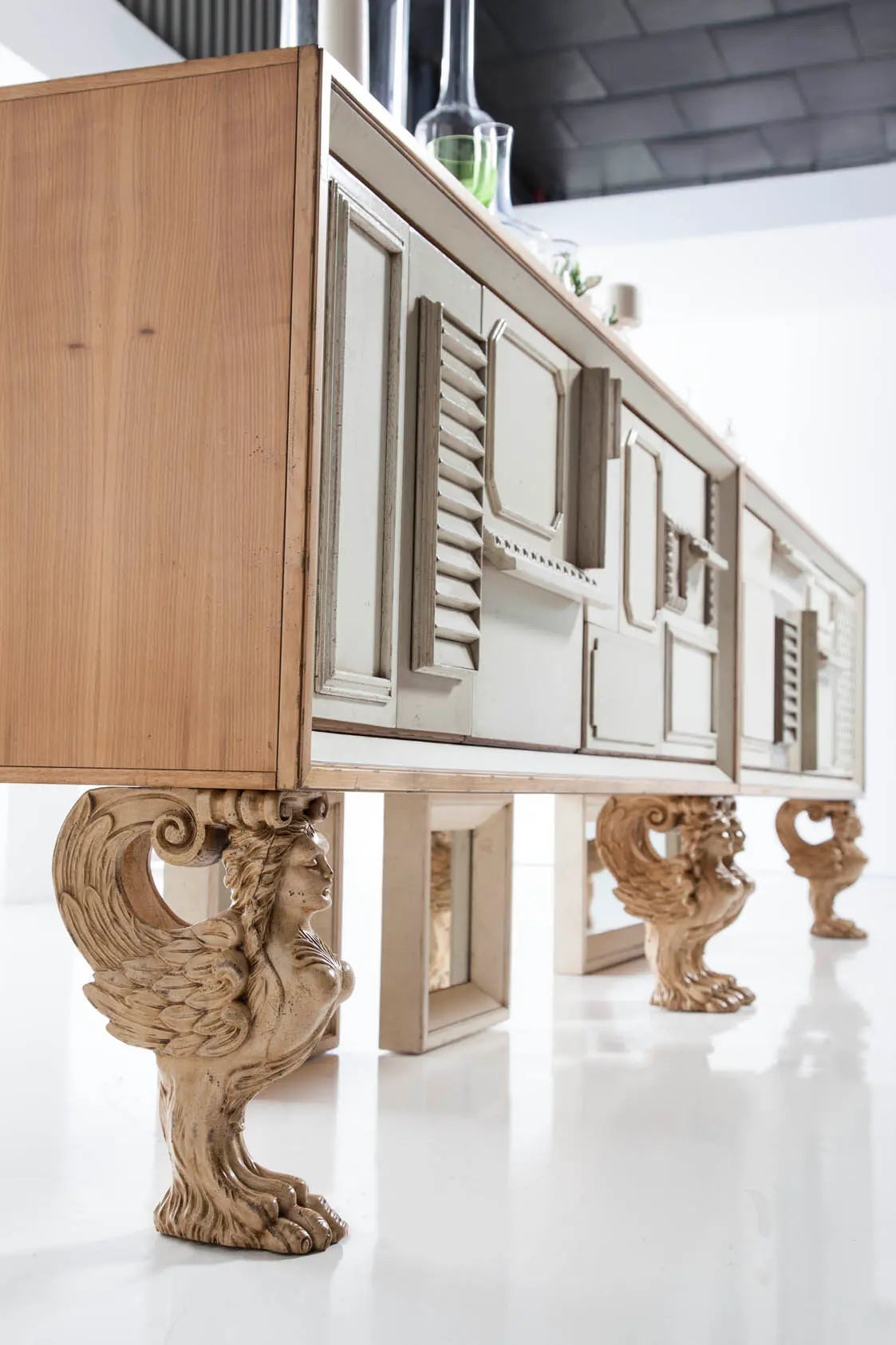 Aparador de diseño Lamassu en madera clara con patas escultóricas en un interior elegante