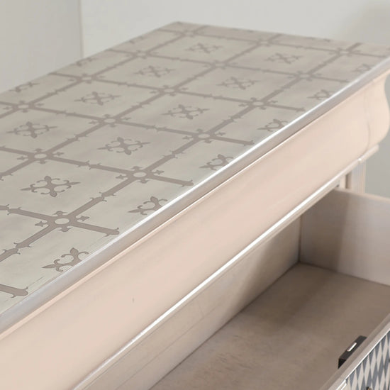 Detalle del sobre del mueble Giulietta con patrón geométrico en tonos suaves.