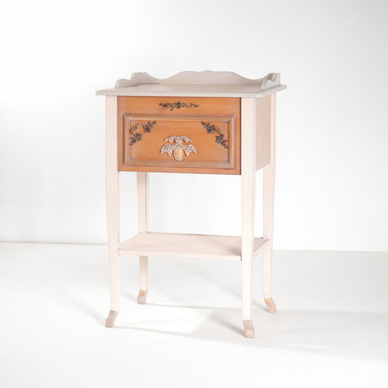 1. Entradita Surprise cerrada, con frontal decorativo en tonos miel, cuerpo marfil y patas estilizadas.