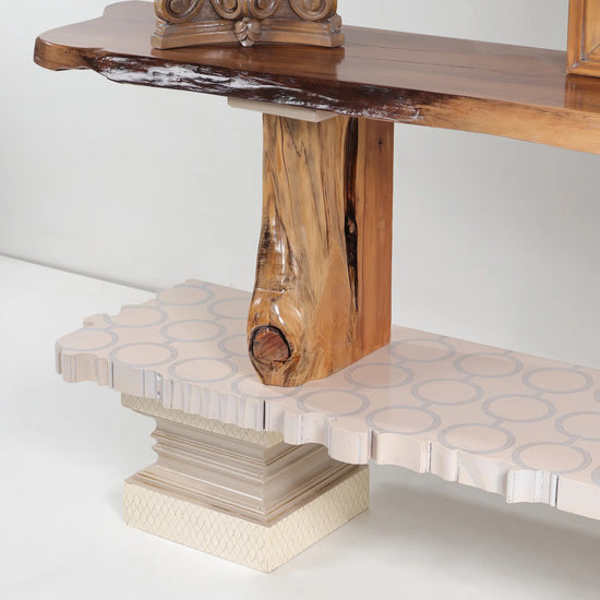Detalle de base clara con motivos circulares y soporte de madera con veta marcada.