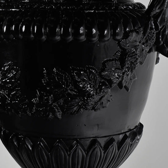 Detalle de relieves florales y guirnaldas del Jarrón Versailles en negro brillante.