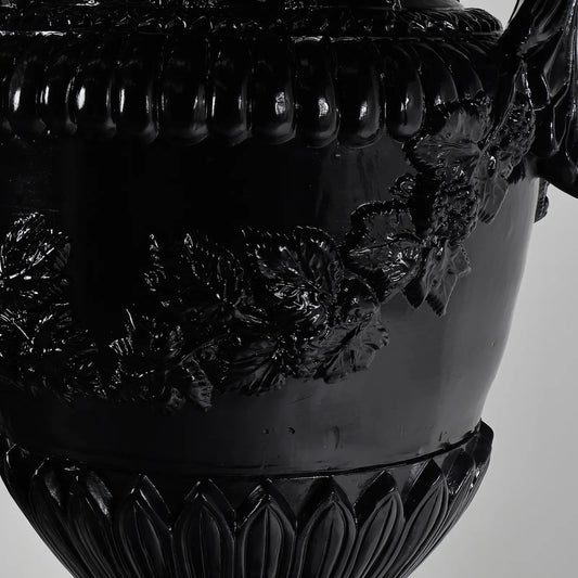 Detalle de relieves florales y guirnaldas del Jarrón Versailles en negro brillante.