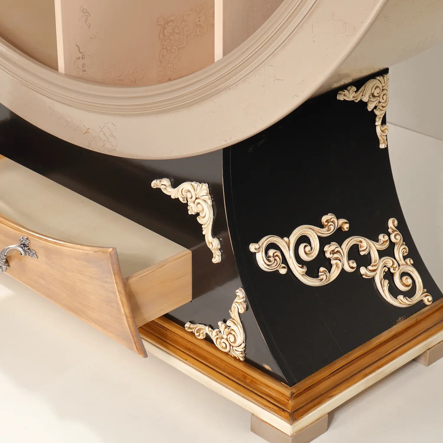 Detalle del cajón inferior y base negra del Librero Globo con ornamentos tallados.