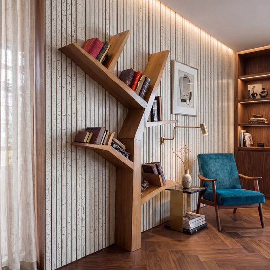 Estantería Tree vertical de diseño en tono madera integrada en una zona de lectura elegante.