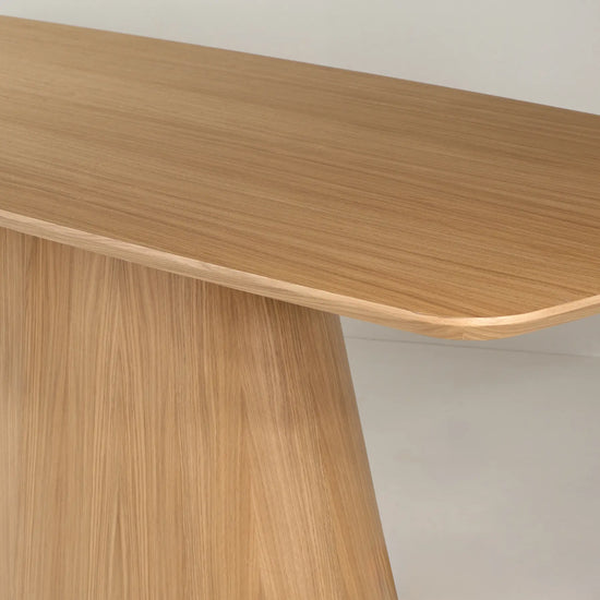 Detalle del tablero redondeado de la mesa de comedor Anastasia en acabado madera.