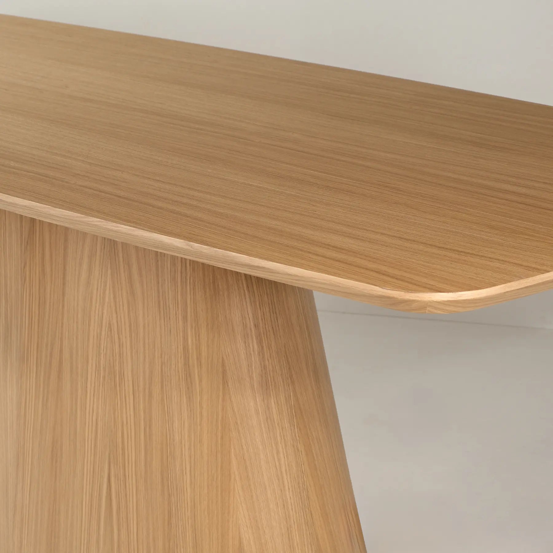 Detalle del tablero redondeado de la mesa de comedor Anastasia en acabado madera.