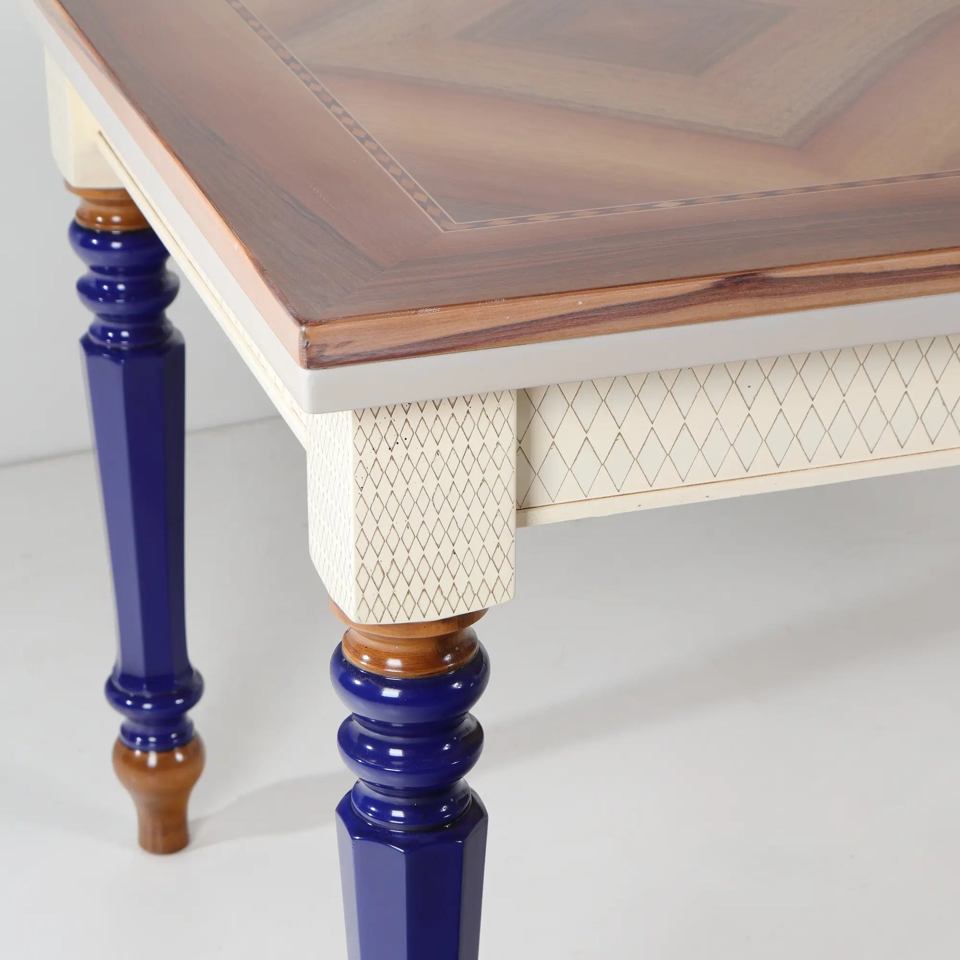 Mesa de comedor extensible Cascabella vista frontal con patas torneadas en azul cobalto.