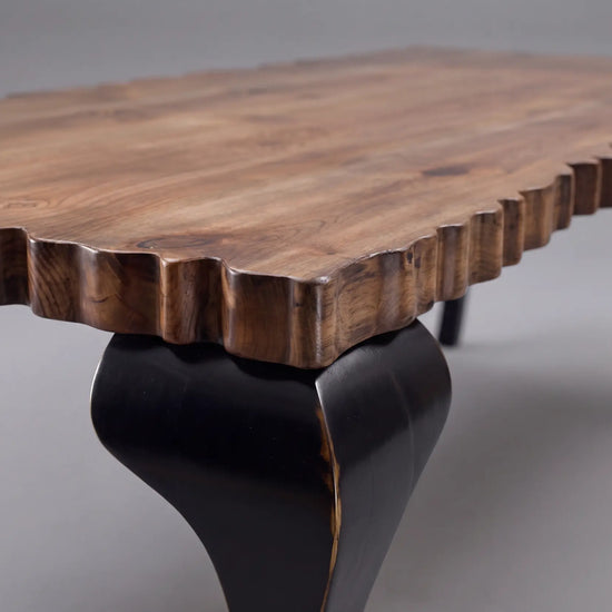 Detalle de la Mesa Charol con sobre de madera tallado y pata negra curva