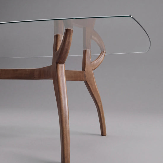 Patas curvas de madera de la Mesa Irati con tapa rectangular de cristal transparente