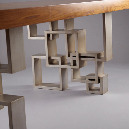 Base geométrica de la Mesa Manhattan con formas rectangulares bajo el sobre de madera