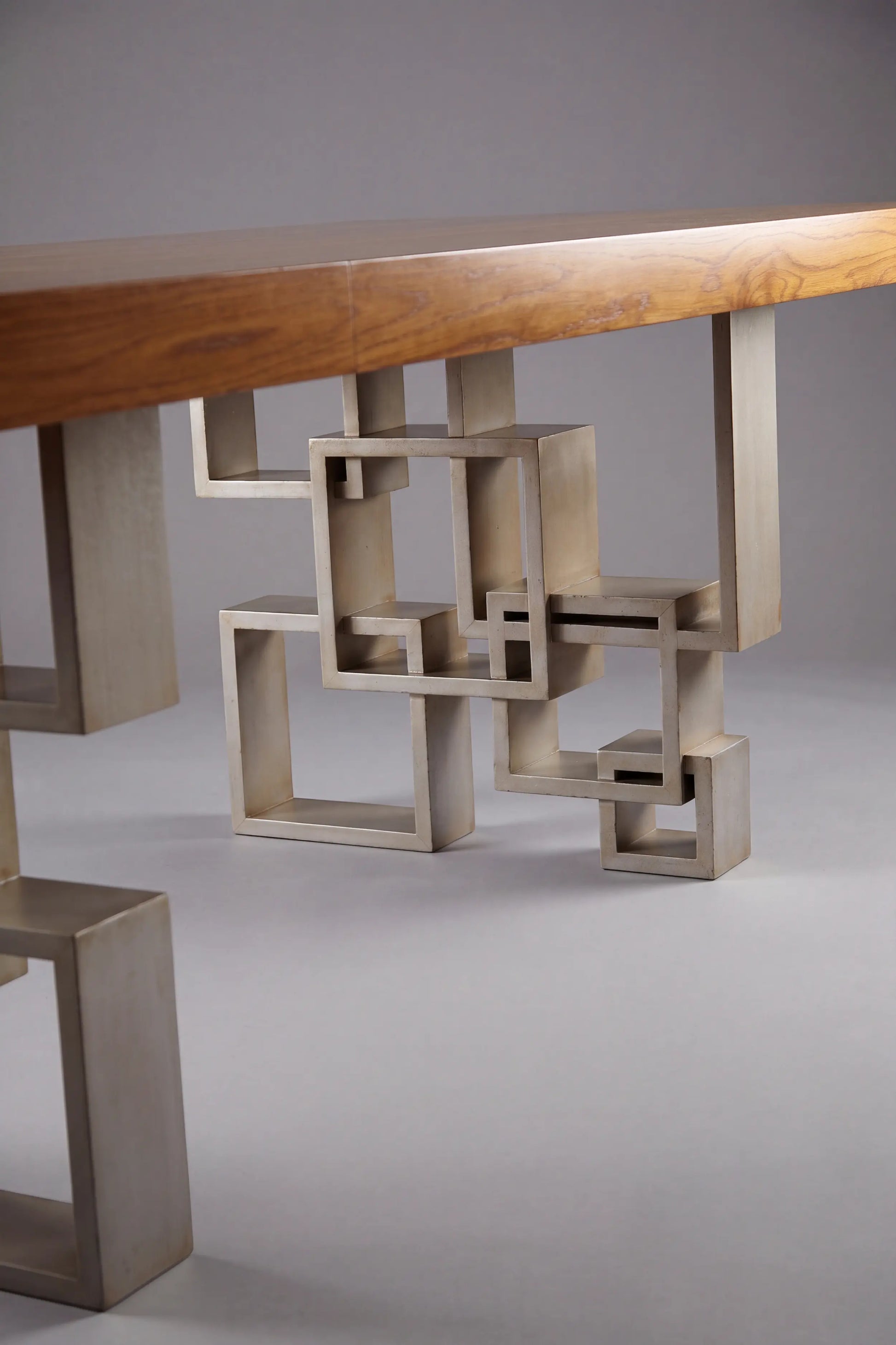 Base geométrica de la Mesa Manhattan con formas rectangulares bajo el sobre de madera