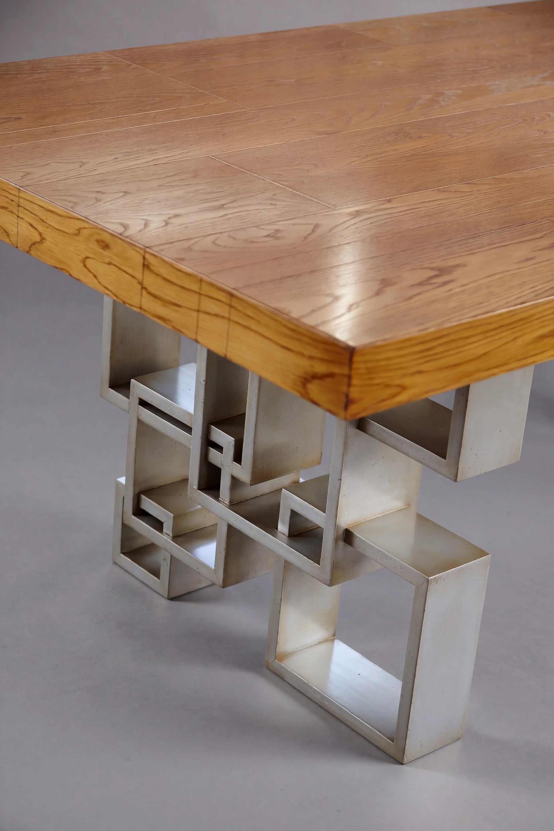 Detalle del sobre de madera de la Mesa Manhattan con base geométrica en acabado claro