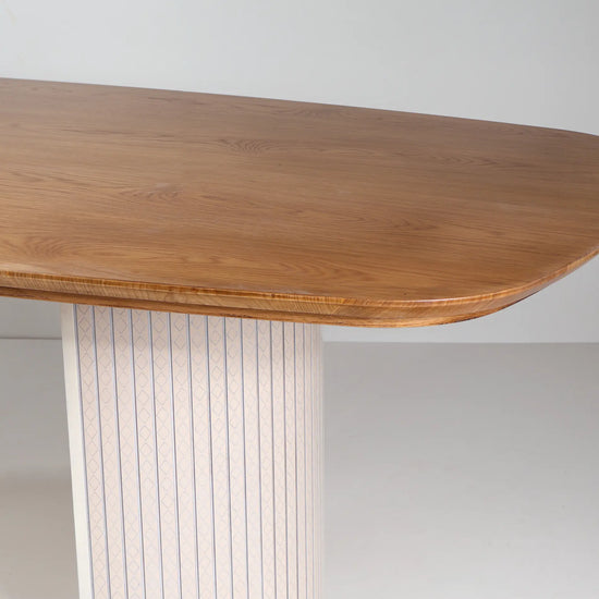 Detalle del sobre de la Mesa Moon en tono madera y pedestal claro con dibujo geométrico.