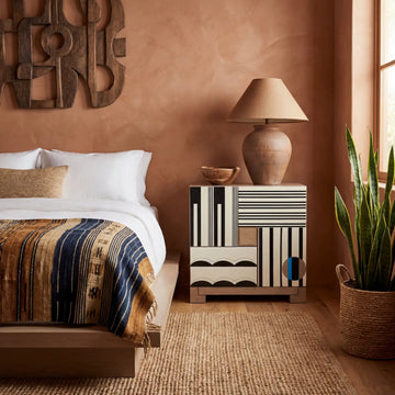 Mesilla África en dormitorio cálido junto a cama, mueble artesanal de diseño exclusivo