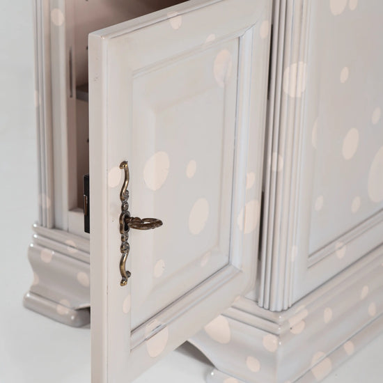 Puerta abierta de la mesilla Giuletta con molduras y tirador de estilo clásico.