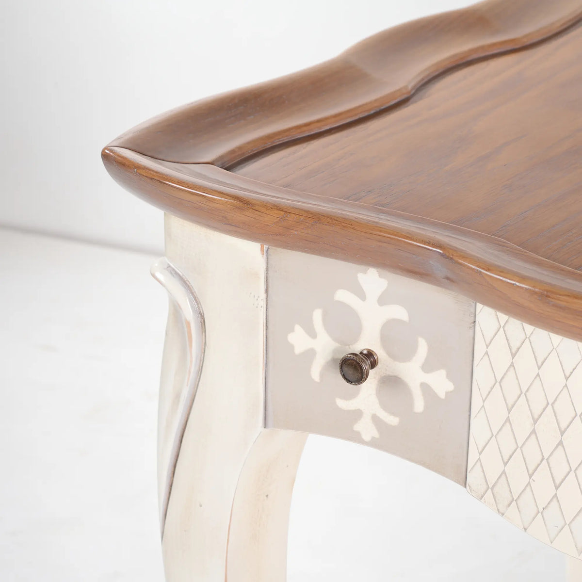 Primer plano de un cajón de la Mesita Cano con decoración ornamental y tirador metálico