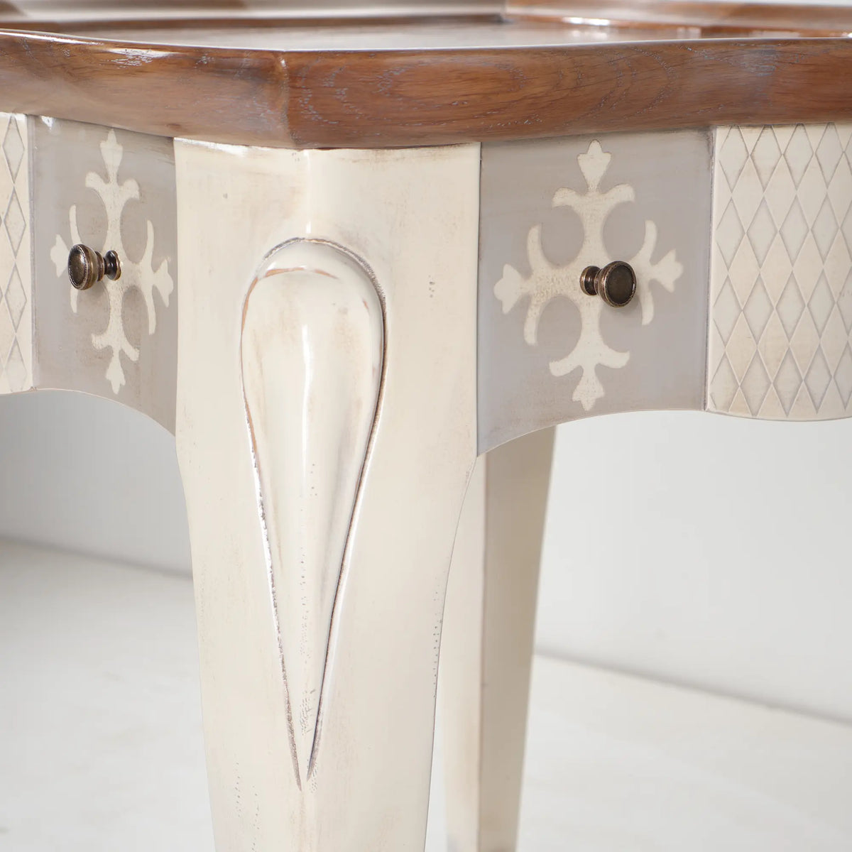 Cajones con motivos ornamentales, tiradores y patas curvas de la Mesa Cano