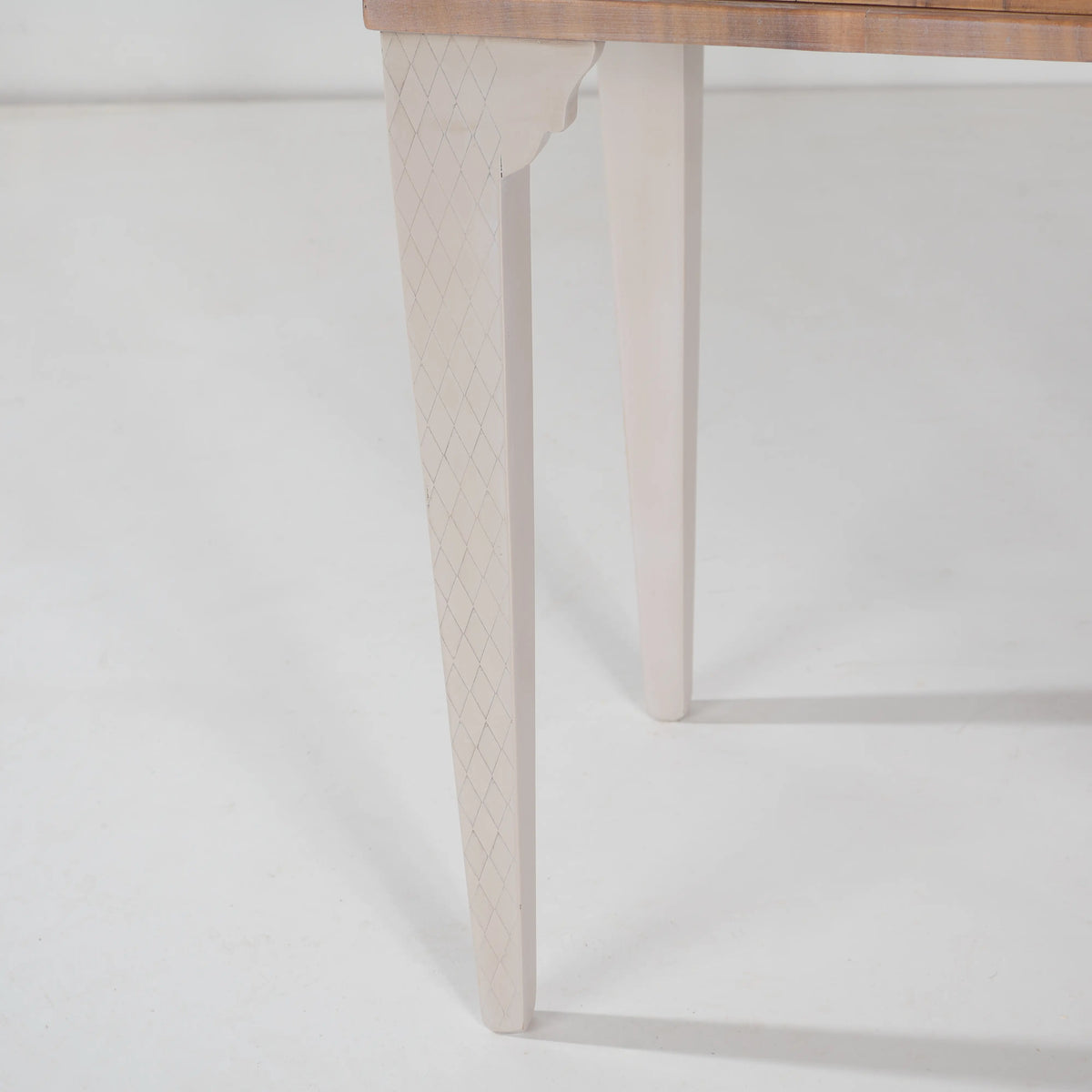 Detalle de las patas claras de la mesita Chely con delicado dibujo geométrico de rombos.