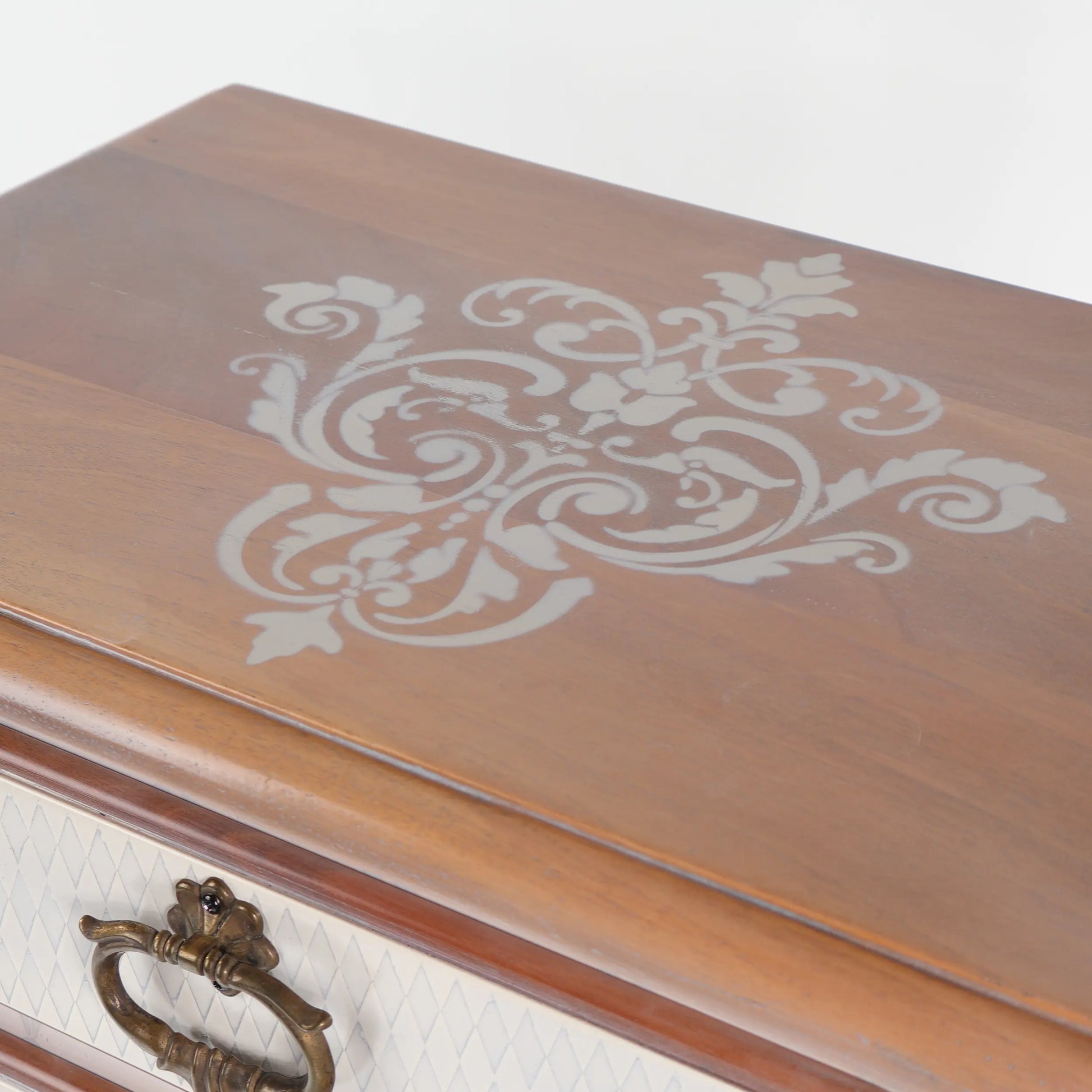 Detalle del sobre de la mesita de noche Nimes con motivo floral decorativo y tirador metálico.