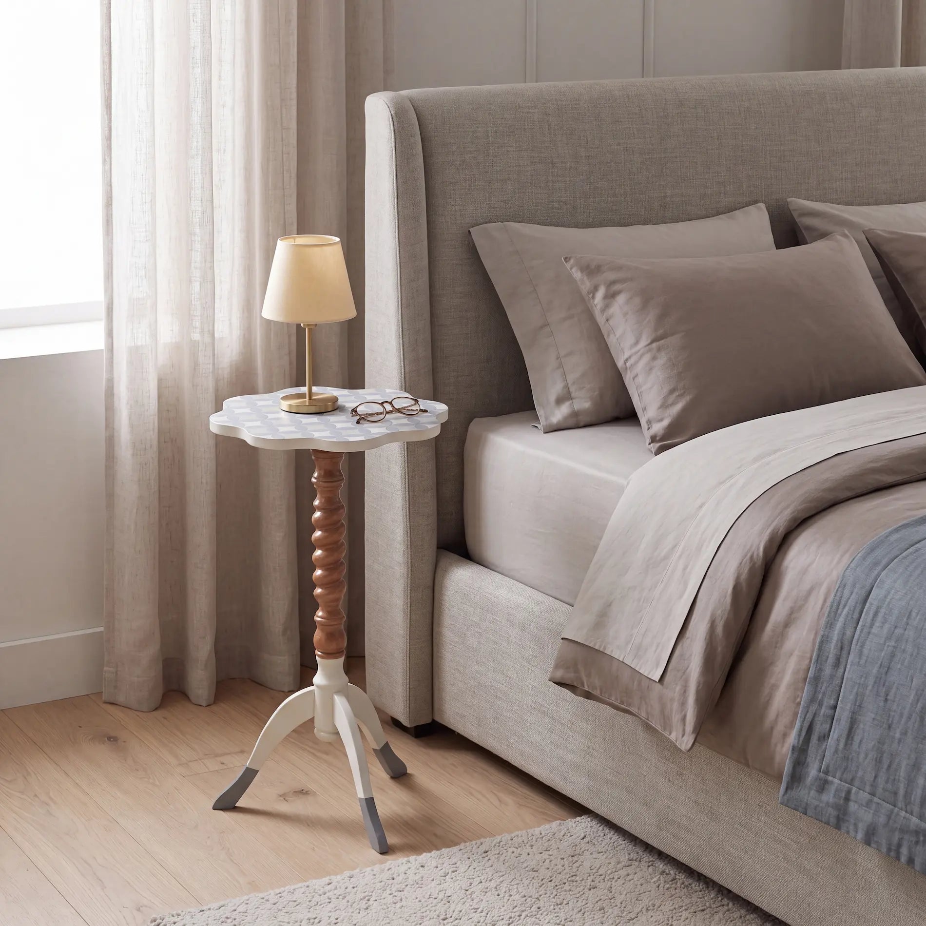Mesita Ondina en un dormitorio elegante junto a la cama, usada como apoyo decorativo